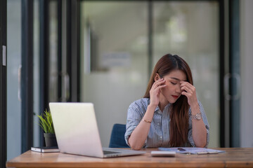Asian businesswoman gets stressed while having a problem at work in the office.