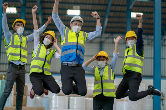 Soft Blur Of Group Of Factory Workers Man And Woman Jump With Happy Action In Warehouse Workplace Area.