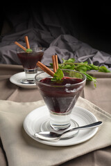 chilled raspberry jelly pudding dessert in glass with cinnamon stick and mint leaf Peruvian cuisine...