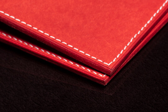 Part of a red leather wallet or purse close-up.