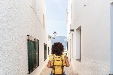 Horizontal view of unrecognizable woman with yellow backpack. Travel and holidays concept in summer.