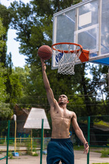 Workout. Young strong man, male basketball player training at street public stadium, sport court or palyground outdoors. Concept of healthy active lifestyle, motion, hobby.