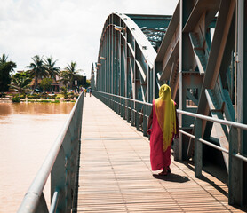 Local woman walking on the Faidherbe Bridge over the Sénégal River, which links the island of the city of Saint-Louis in Senegal to the African mainland