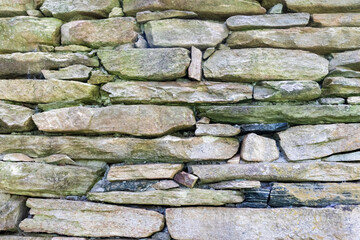 Rock wall made from flat stones used as a background or wallpaper