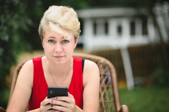 Young person outdoors with cell phone in hands 