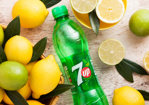 LONDON, UK - APRIL 27, 2018: Plastic bottle of 7UP lemonade soda drink with fresh lemons and limes on wooden background.Top view