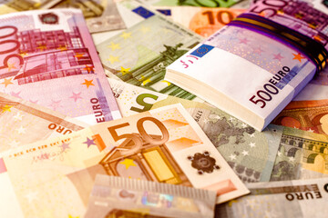 A pack of European currency lies on the background of the Euro
