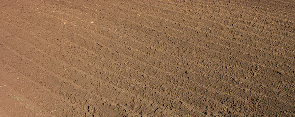 Deep furrows in the field after plowing, wide view