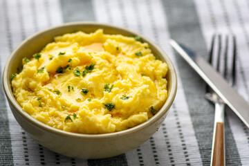 Close up image of mashed potatoes and herbs on a textured background. 