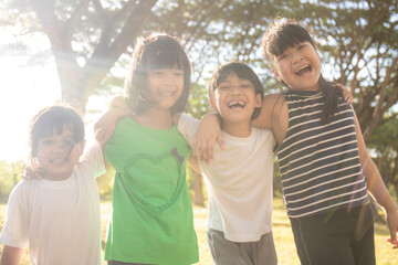 Group of kindergarten kids friends arm around and smiling fun With sunset