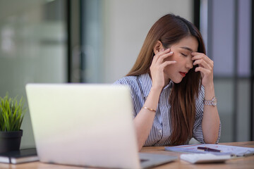 Asian businesswoman gets stressed while having a problem at work in the office.