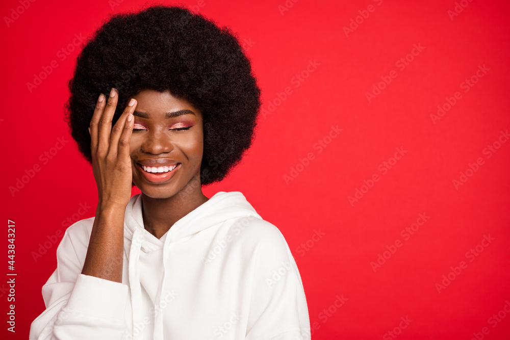 Sticker Photo of cute brunette young lady closed eyes near empty space wear white sportswear isolated on red color background