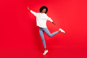 Full size photo of lovely wavy hairdo lady dance wear white sportswear jeans isolated on red color background