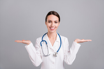 Photo of confident pretty young doc woman dressed white coat showing arms scales empty space...