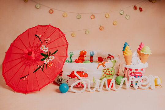 Summer photoshoot in studio for kids with ball swimming pool umbrella and ice cream