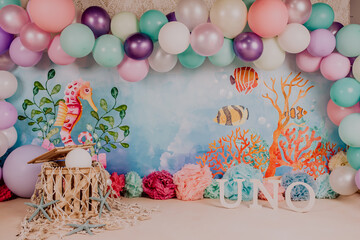 First birthday smashcake photo session of an under the sea and little mermaid theme in a photo...