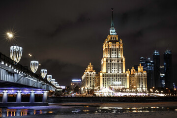 Night building of the Stalinist skyscraper of the Ukraina hotel on the Moscow river across the Novoarbatsky bridge