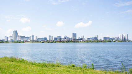 Naklejka premium Panorama of modern buildings against the blue sky. Modern buildings overlooking a street landscape with a river.
