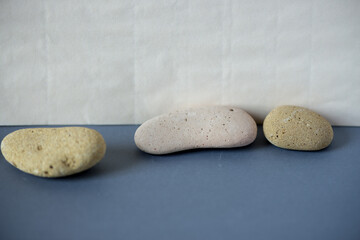 Fototapeta na wymiar three yellow bone white stones arranged on a blue gray and ivory yellow background