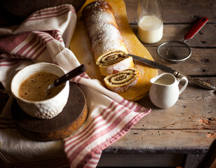 Tasty cake roll and coffee on old wooden table. Rustic style