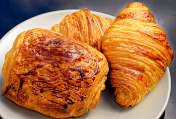 Fresh croissants and pain au chocolate on a plate