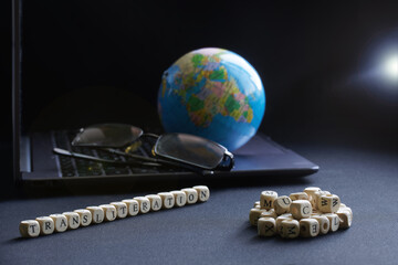 Transliteration lettering next to laptop, glasses and globe. Concept of work on translation and...