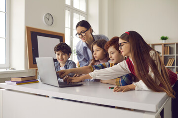 Smart children pupil pointing at laptop screen while discussing media material or online project...