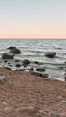 Peaceful landscape of Baltic seashore with sand and rocks.