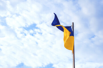 The blue-yellow flag of Ukraine develops against the background of sky. Constitution Day, Flag Day, Independence Day of Ukraine.