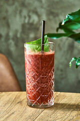 Alcoholic cocktail strawberry and basil mojito with lime and mint in a glass with ice