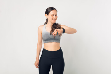 Fitness woman using fitness tracker on wrist over white background. A woman using a smartwatch