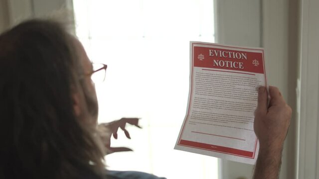 Man Receiving an Eviction Notice and He Reads it