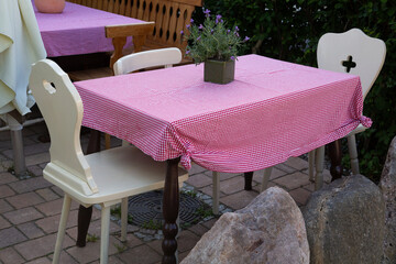 Rustic empty outdoor tables and chairs with tableclothes