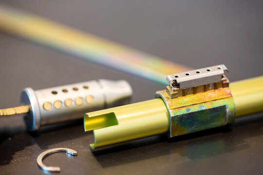 Spring compressed cylinder lock with pins exposed.  Various tools and parts shown in the background