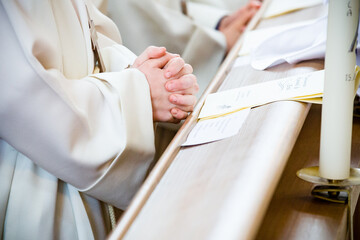 Betende Kinderhände bei der Kommunion in der katholischen Kirche