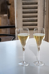 Romantic party with two glasses of white cold champagne and view on old street in French village