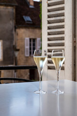 Romantic party with two glasses of white cold champagne and view on old street in French village