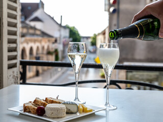 Romantic party with two glasses of white cold champagne and view on old street in French village