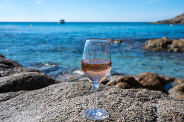 Summer time in Provence, glass of cold rose wine on sandy beach and blue sea near Saint-Tropez, Var department, France