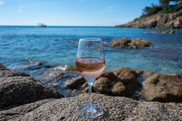 Summer time in Provence, glass of cold rose wine on sandy beach and blue sea near Saint-Tropez, Var department, France