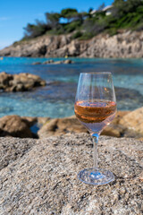 Summer time in Provence, glass of cold rose wine on sandy beach and blue sea near Saint-Tropez, Var department, France