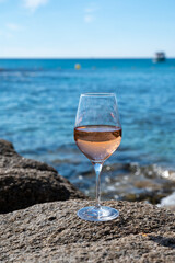 Summer time in Provence, glass of cold rose wine on sandy beach and blue sea near Saint-Tropez, Var department, France