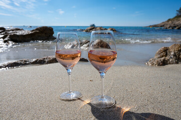Summer time in Provence, two glasses of cold rose wine on sandy beach near Saint-Tropez, Var department, France