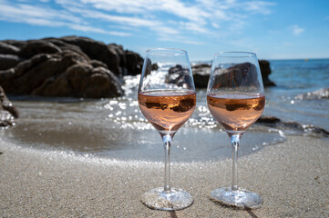 Summer time in Provence, two glasses of cold rose wine on sandy beach near Saint-Tropez, Var department, France