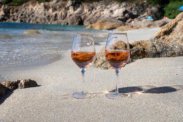 Summer time in Provence, two glasses of cold rose wine on sandy beach near Saint-Tropez, Var department, France