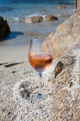 Summer time in Provence, glass of cold rose wine on sandy beach near Saint-Tropez, Var department, France