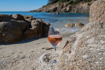 Summer time in Provence, glass of cold rose wine on sandy beach near Saint-Tropez, Var department,...