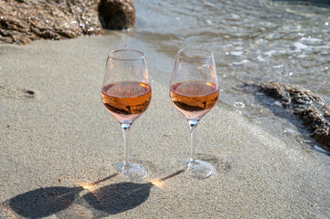 Summer time in Provence, two glasses of cold rose wine on sandy beach near Saint-Tropez, Var department, France
