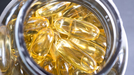 Astonishing closeup of Omega 3 capsules (pills), stacked together in a plastic container. Medical journals and life sciences concept.