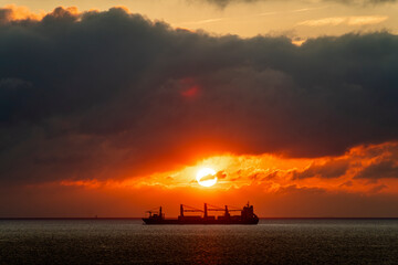 Silhouette of a cargo ship at sunset